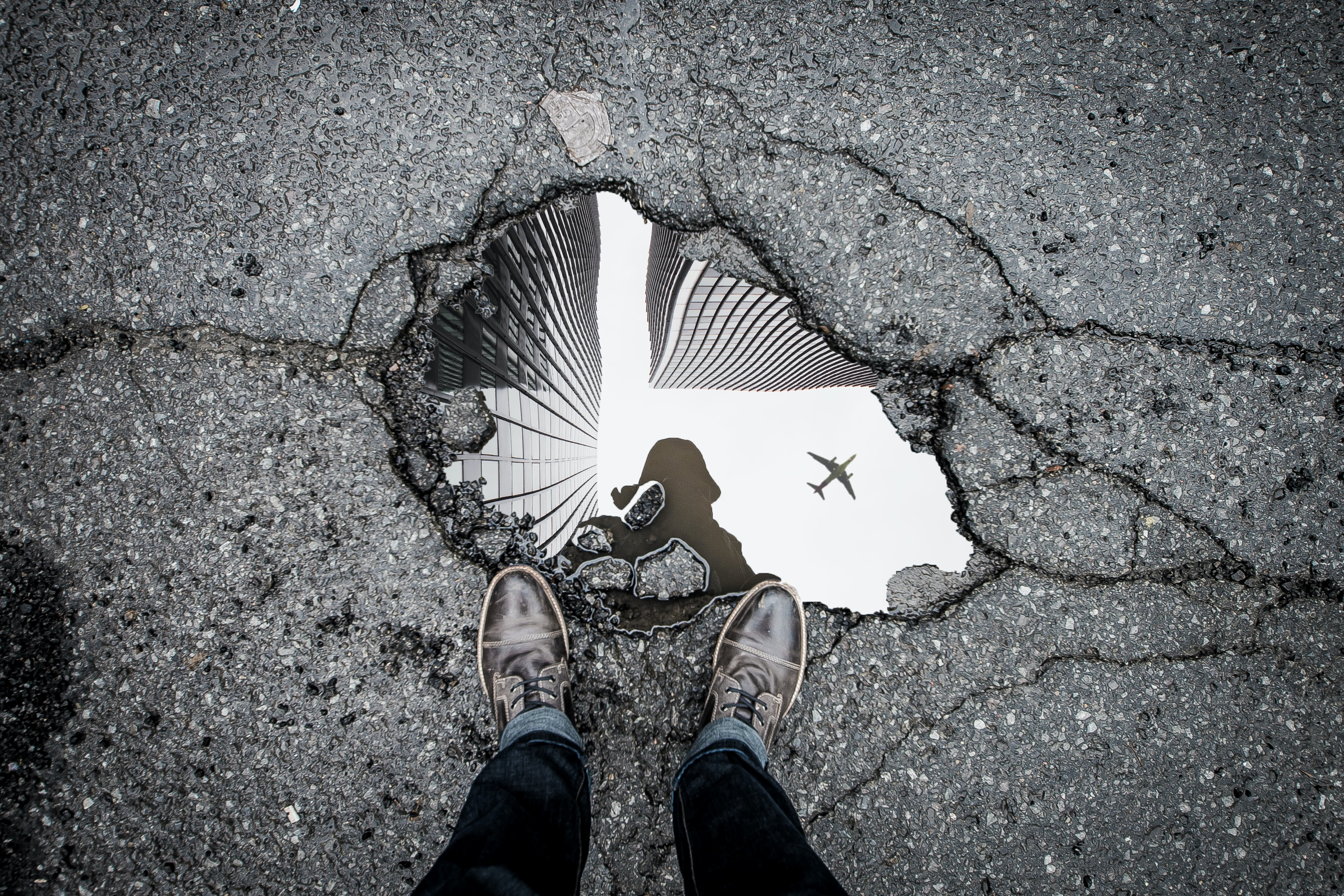 Puddle in pavement reflecting person above